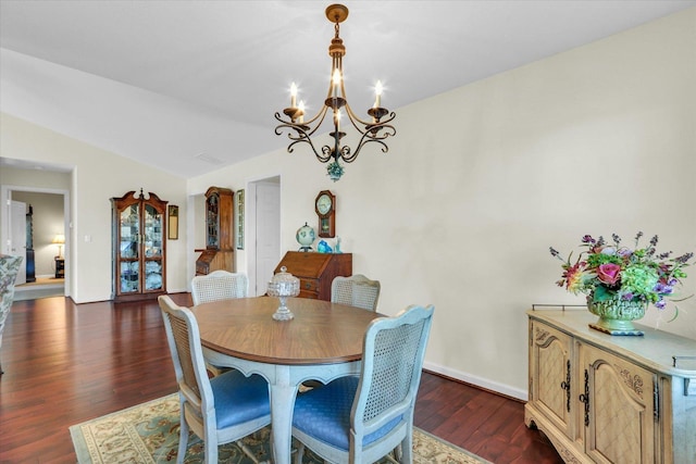 dining room with an inviting chandelier, vaulted ceiling, and dark hardwood / wood-style floors