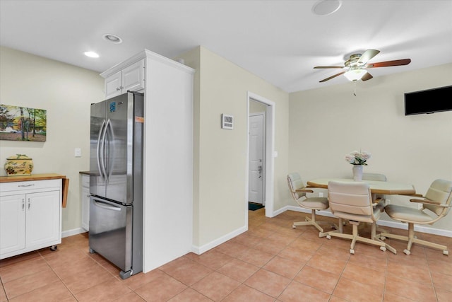 kitchen featuring white cabinetry, stainless steel refrigerator, ceiling fan, and light tile patterned flooring