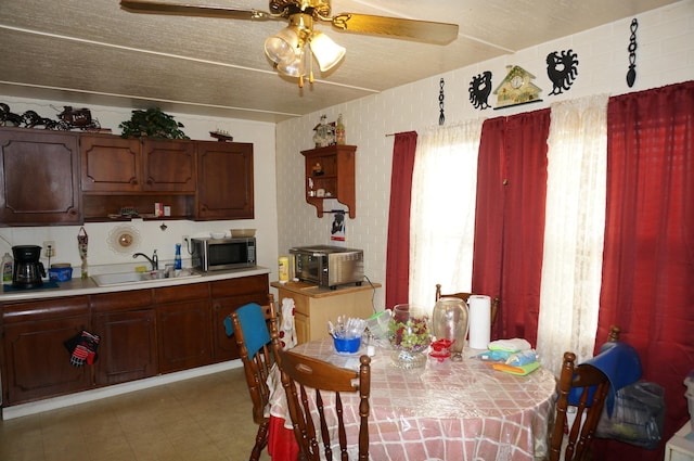 dining space featuring ceiling fan and sink