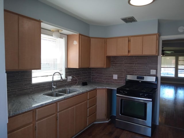 kitchen featuring stainless steel range with gas stovetop, decorative backsplash, dark hardwood / wood-style flooring, and sink