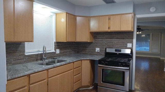 kitchen with sink, stainless steel gas range, dark hardwood / wood-style floors, light brown cabinetry, and decorative backsplash