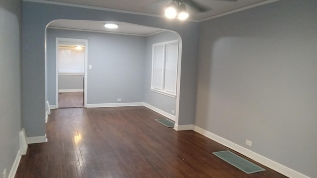 unfurnished room with dark hardwood / wood-style flooring, ornamental molding, and ceiling fan