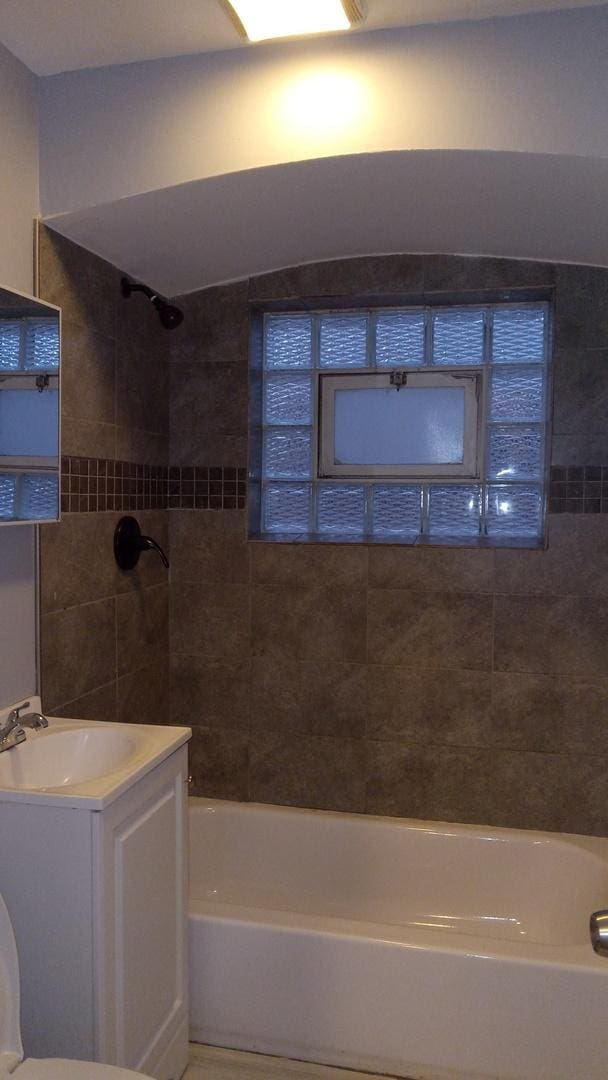 full bathroom with vanity, toilet, and tiled shower / bath