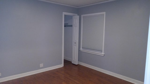 spare room with ornamental molding and dark hardwood / wood-style floors