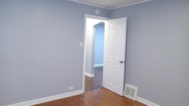 empty room with hardwood / wood-style flooring and ornamental molding