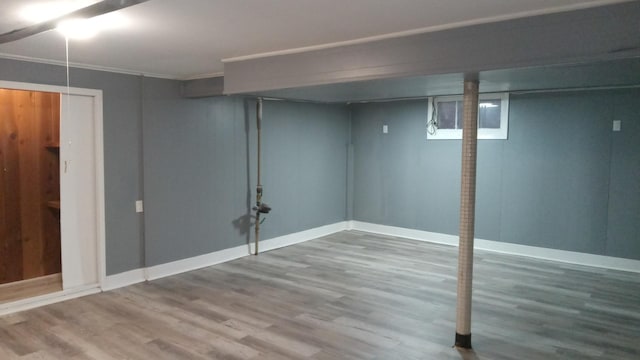 basement with wood-type flooring and ornamental molding