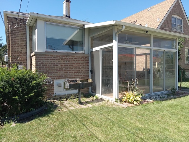 view of side of property with a yard and a sunroom