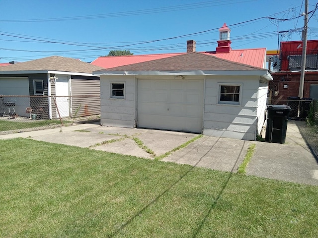 back of property featuring a garage, an outbuilding, and a lawn