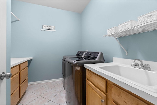 washroom featuring light tile patterned floors, sink, cabinets, and washer and dryer