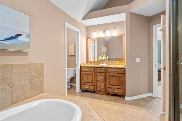 bathroom featuring vaulted ceiling, vanity, a relaxing tiled tub, toilet, and tile patterned floors