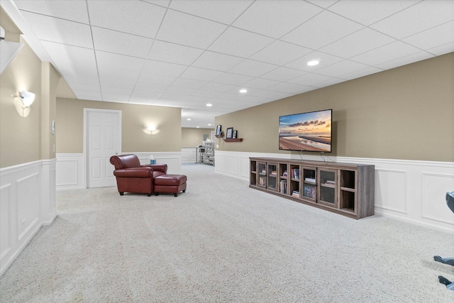 carpeted living room featuring a paneled ceiling