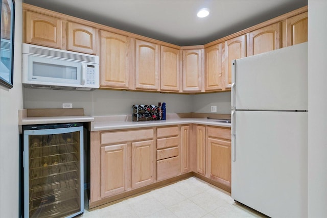 kitchen featuring light brown cabinets, wine cooler, and white appliances