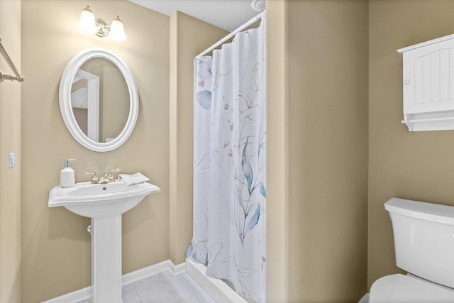 bathroom featuring toilet, sink, tile patterned floors, and walk in shower