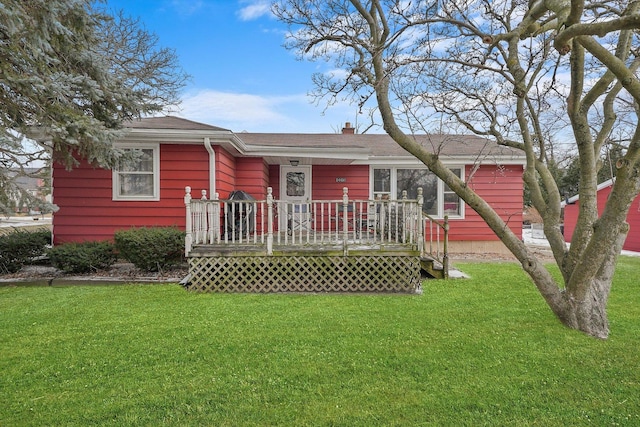 back of property featuring a wooden deck and a yard