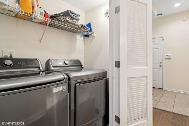 clothes washing area featuring hardwood / wood-style flooring and washer and dryer