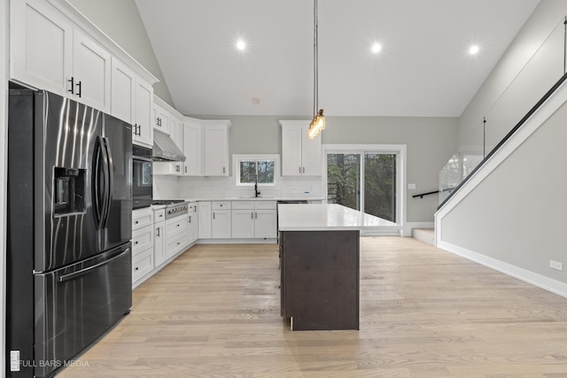 kitchen featuring pendant lighting, backsplash, white cabinetry, and appliances with stainless steel finishes