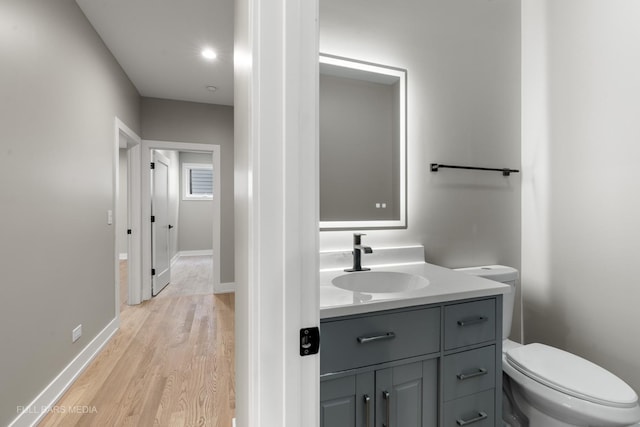 bathroom featuring vanity, hardwood / wood-style flooring, and toilet