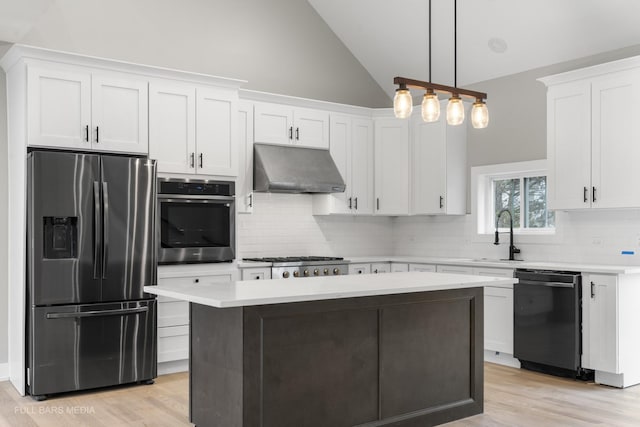 kitchen with extractor fan, white cabinetry, sink, pendant lighting, and stainless steel appliances