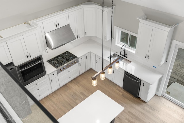 kitchen with white cabinets, stainless steel appliances, and light wood-type flooring