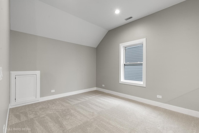 additional living space with vaulted ceiling and light colored carpet