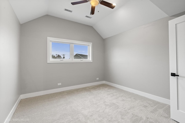 spare room featuring vaulted ceiling, ceiling fan, and light colored carpet