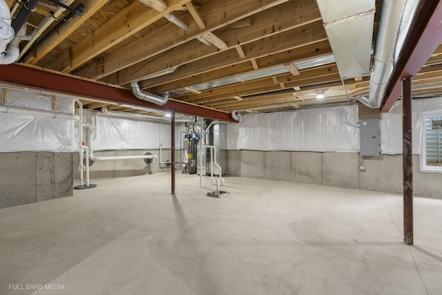 basement featuring electric panel and water heater