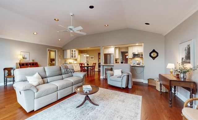 living room with ornamental molding, hardwood / wood-style flooring, vaulted ceiling, and ceiling fan