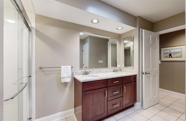 bathroom featuring tile patterned flooring, an enclosed shower, and vanity