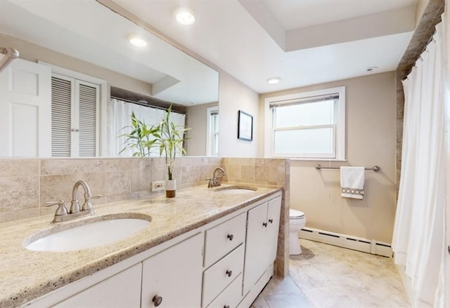 bathroom featuring a tray ceiling, backsplash, toilet, a baseboard radiator, and vanity