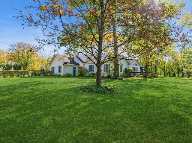 view of front facade featuring a wooden deck and a front lawn