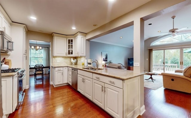 kitchen featuring white cabinetry, kitchen peninsula, stainless steel appliances, sink, and wood-type flooring