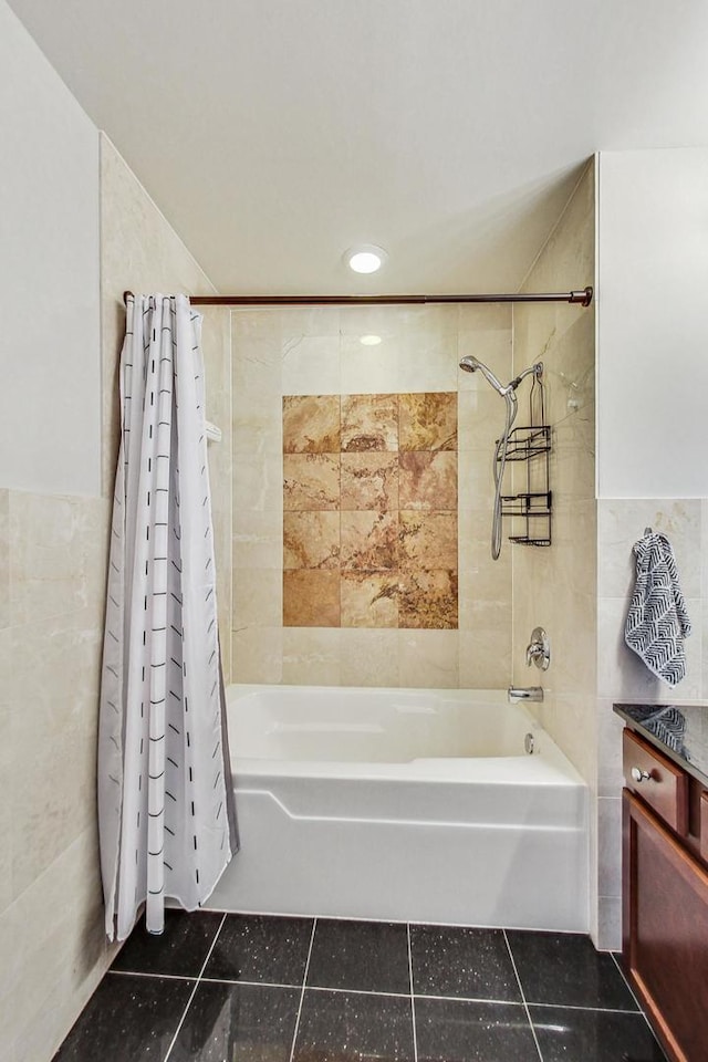 bathroom with shower / tub combo with curtain, tile patterned flooring, and tile walls