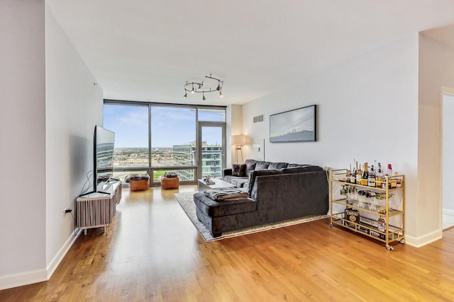 living room with hardwood / wood-style floors, expansive windows, and track lighting