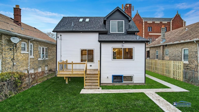 rear view of house with a deck and a yard