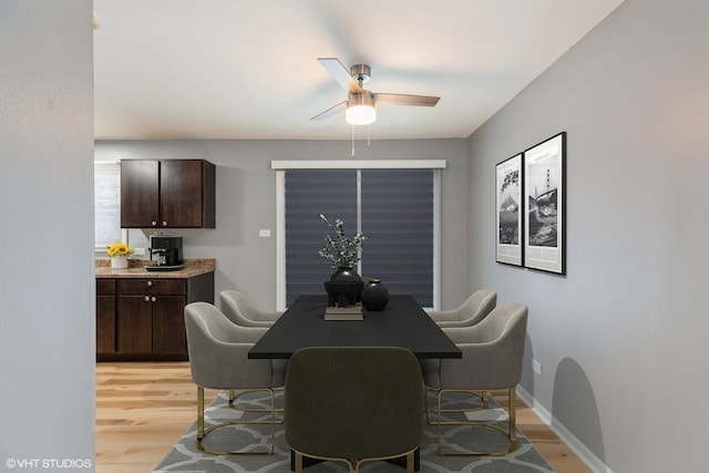 dining space with light hardwood / wood-style floors and ceiling fan