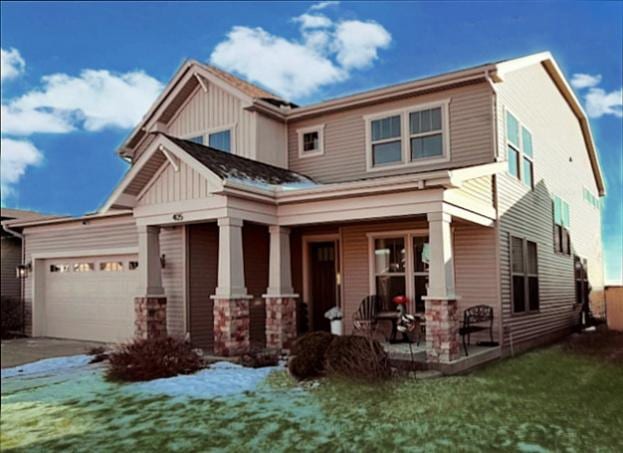 craftsman inspired home with a garage, a front yard, and covered porch