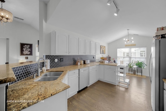 kitchen with white cabinetry, kitchen peninsula, and hanging light fixtures