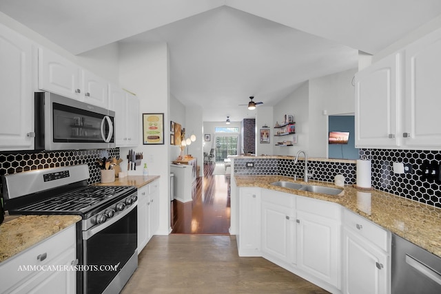 kitchen featuring appliances with stainless steel finishes, white cabinetry, sink, ceiling fan, and kitchen peninsula