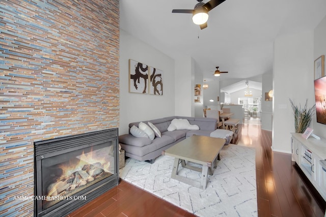 living room featuring ceiling fan, a large fireplace, wood-type flooring, and lofted ceiling