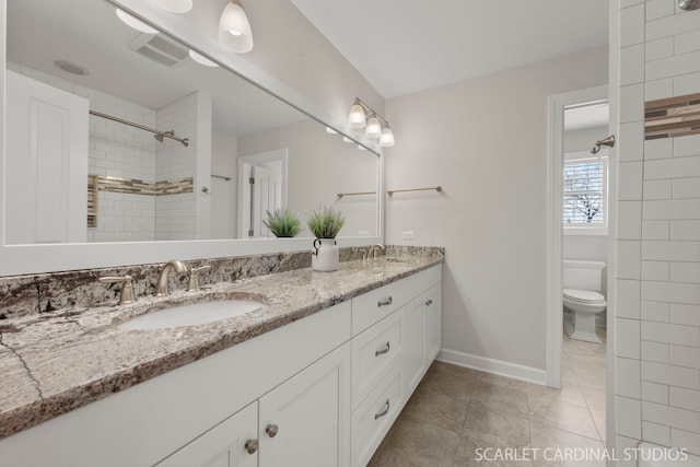 bathroom featuring vanity, a tile shower, tile patterned floors, and toilet