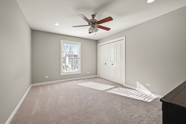 unfurnished bedroom featuring carpet, ceiling fan, and a closet