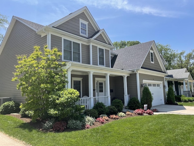 craftsman-style home featuring a garage, central AC unit, covered porch, and a front lawn