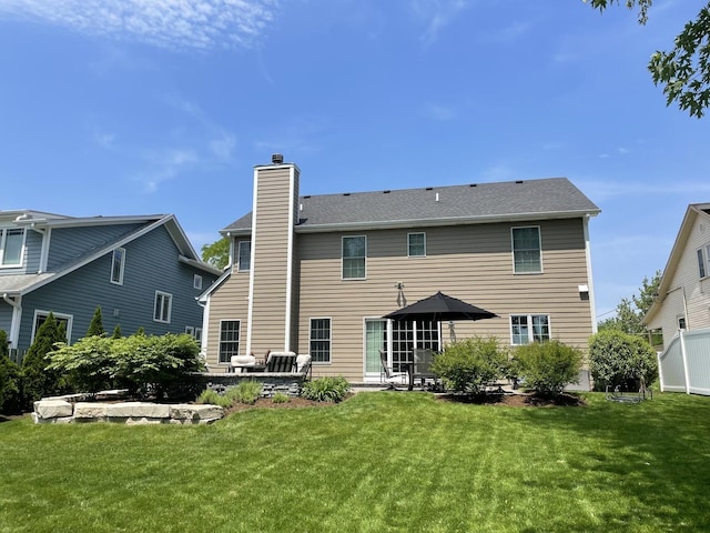 rear view of house featuring a patio area and a lawn