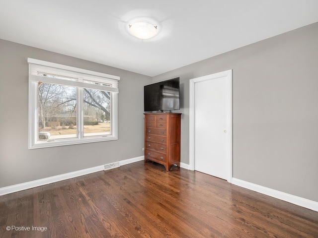 unfurnished bedroom with dark hardwood / wood-style floors