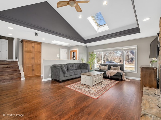 living room with ceiling fan, dark hardwood / wood-style floors, and a skylight