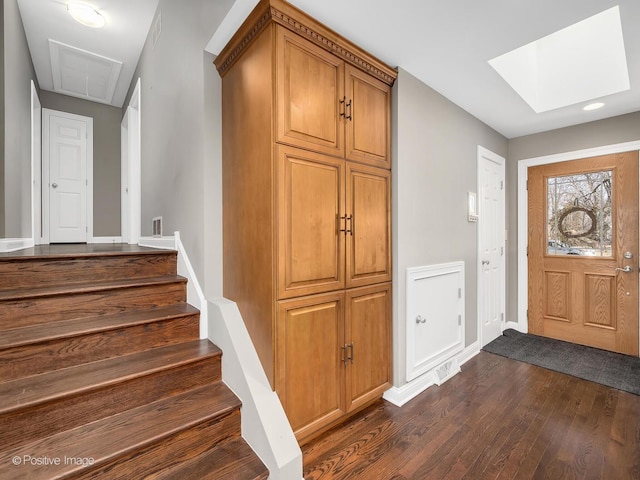 entrance foyer featuring dark wood-type flooring and a skylight