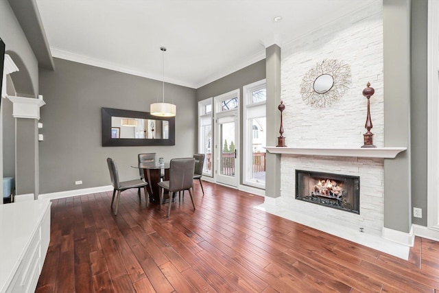 dining space with ornamental molding, hardwood / wood-style floors, and a fireplace