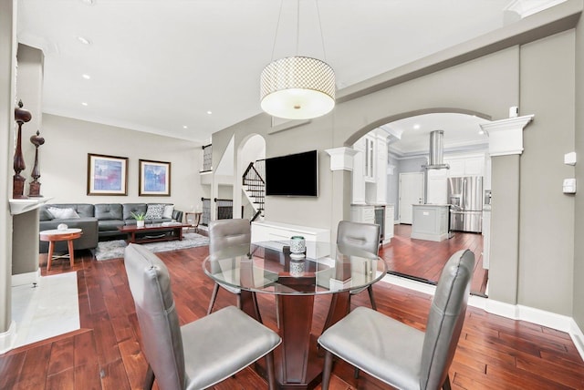 dining space featuring ornamental molding and dark hardwood / wood-style flooring