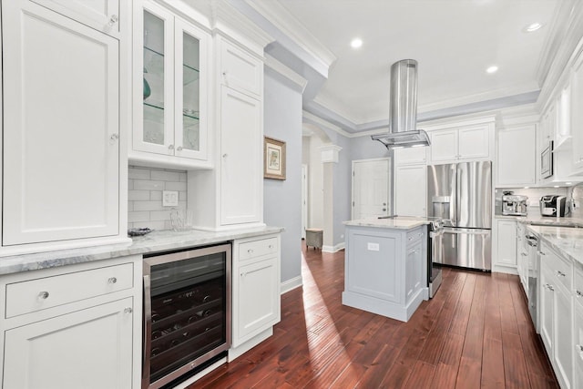 kitchen featuring wine cooler, white cabinetry, island exhaust hood, stainless steel appliances, and light stone countertops