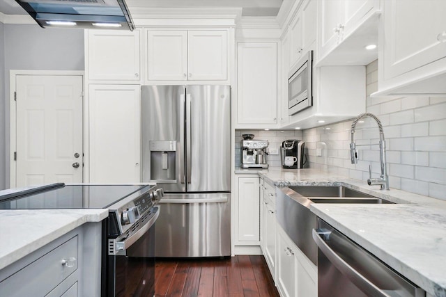 kitchen featuring white cabinetry, appliances with stainless steel finishes, dark wood-type flooring, and light stone counters